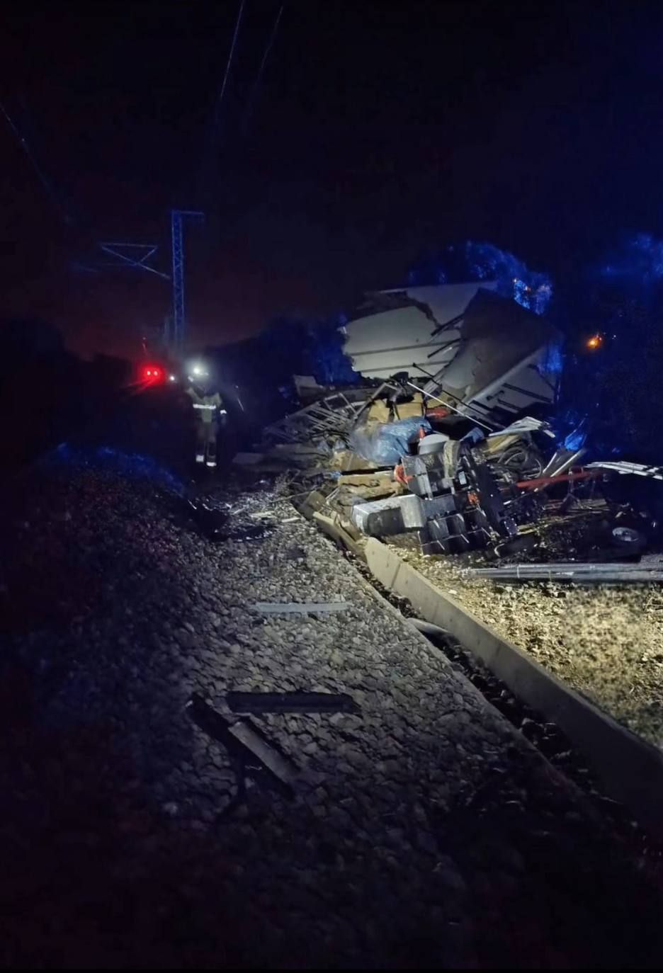 Un agente camina por el lugar de la tragedia junto a las vías del tren en la A-62.