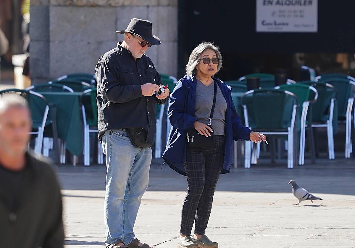 Una pareja se dispone a fumar durante un paseo por la Plaza Mayor de Salamanca.
