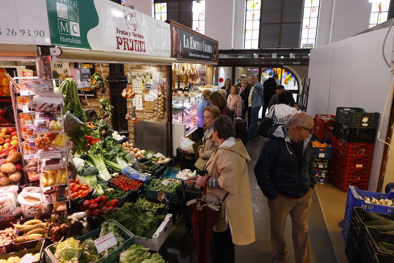 Varias personas, esperando a ser atendidas en una frutería.