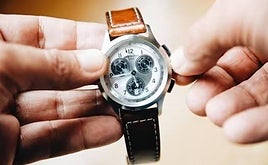 Una persona cambia la hora de su reloj.