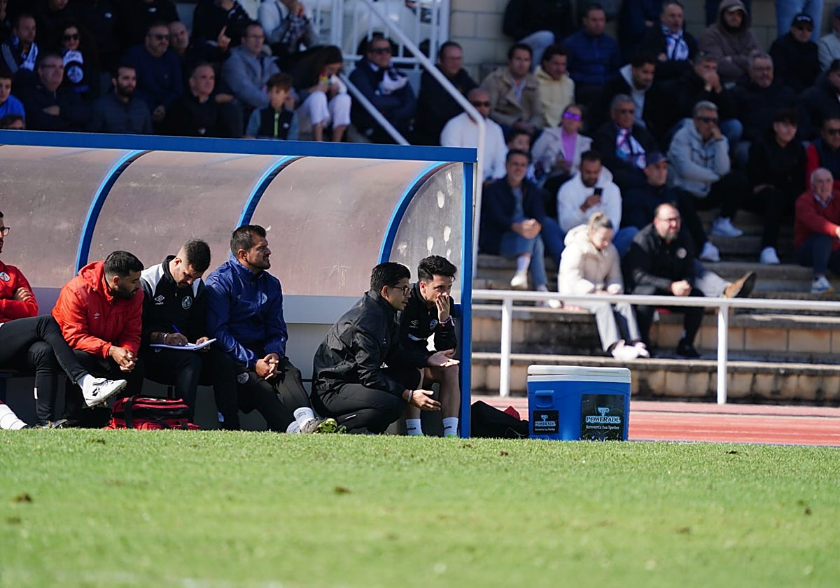 Jorge García sentado en su banquillo escuchando a Álvaro Boyero.