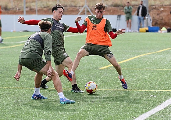 Jota trata de proteger el esférico mientras que Juanje y Piñán le intentan birlar el balón en un ejercicio de entrenamiento de la presente semana.