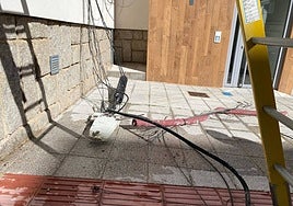 Cables y cajas de la red de comunicación en en suelo en una de las fachadas de la calle Margaritas este lunes.