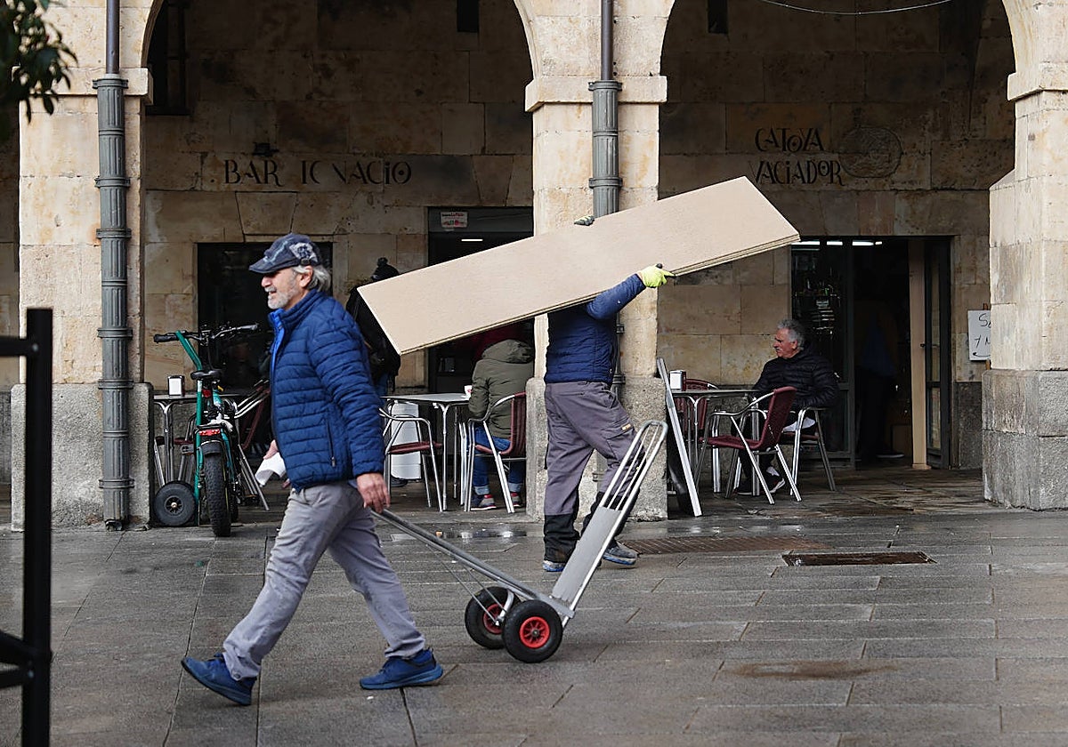 Dos trabajadores por la plaza del Mercado.