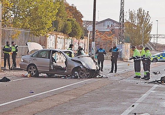 Agentes de la Policía Local de Salamanca y operarios municipales, junto al vehículo siniestrado tras el accidente mortal en la calle Calzada de Medina.