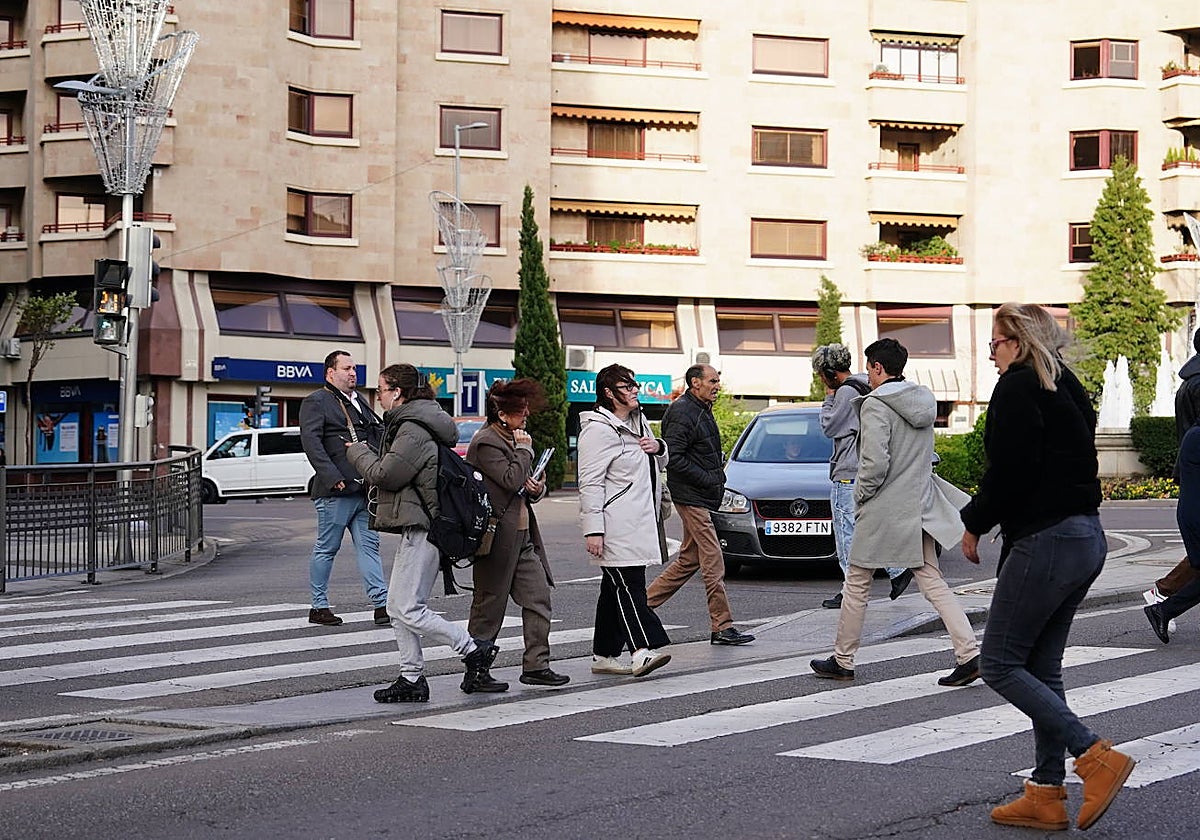 Un grupo de personas, cruzando un paso de peatones de la Puerta de Zamora.