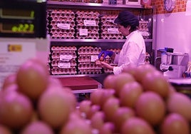 Ana García selecciona huevos en su puesto de alimentación.