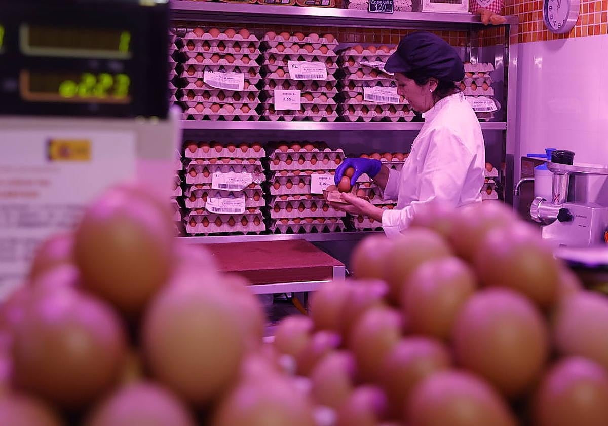 Ana García selecciona huevos en su puesto de alimentación.