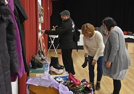 Organizadoras del evento junto a uno de los stands de zapatos del mercadillo solidario.
