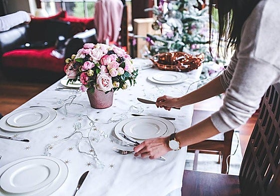 Preparación de una mesa para celebrar una comida navideña.