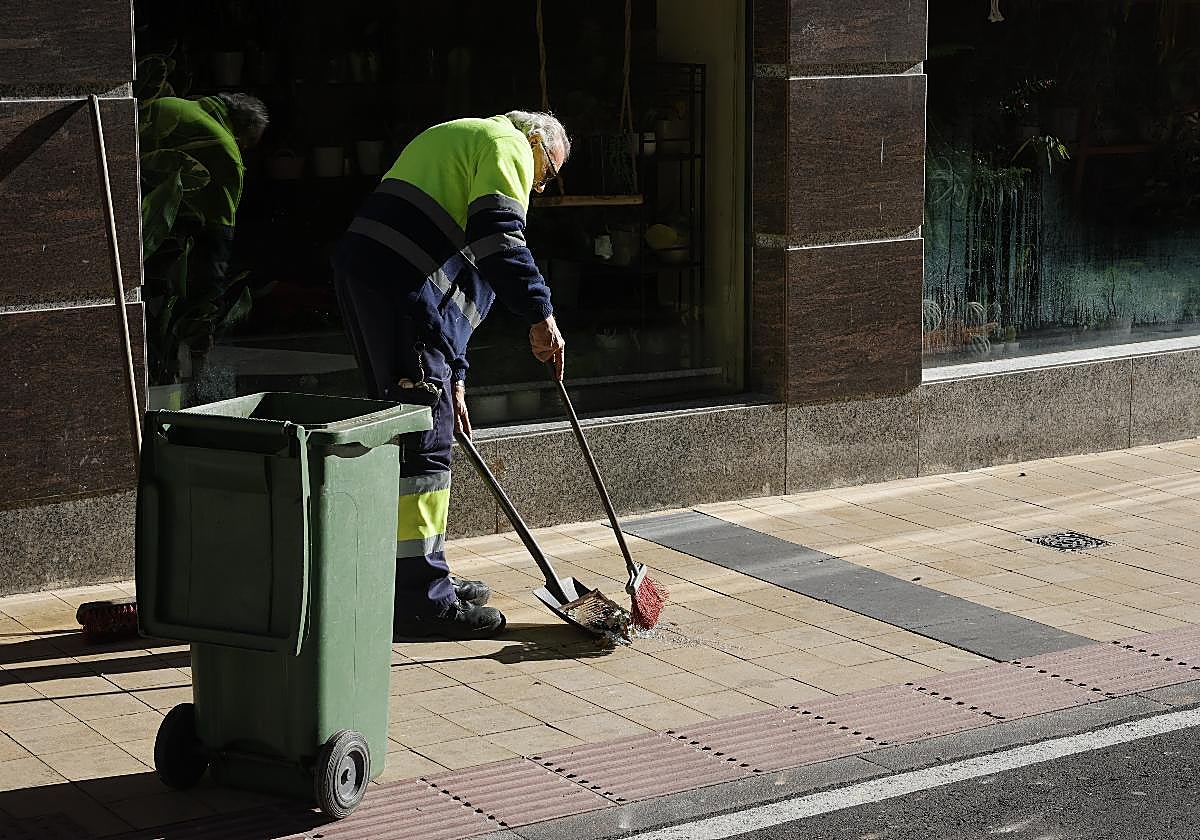 Un operario retira la rejilla de la salida de humos y los cristales que cayeron a la calle.