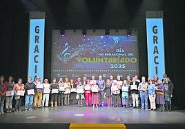 Los voluntarios reconocidos por su labor se hacen la tradicional foto de familia con el alcalde de la ciudad Carlos García Carbayo.