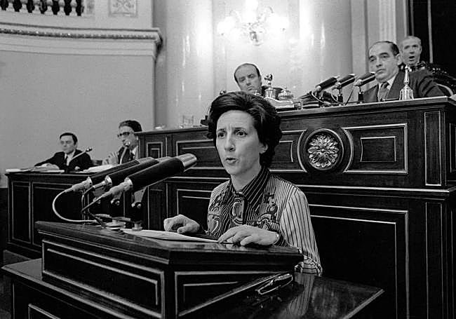 EN EL SENADO. Gloria Begué, en una intervención parlamentaria durante un Plano del Senado, celebrado el 18 de noviembre de 1977. Ese mismo año habría sido nombrada senadora por designación real, una prerrogativa que entonces correspondía al monarca. Tras la cadrática, el presidente del Senado en la época, Antonio Fontán. A su espalda, un ujier bosteza.
