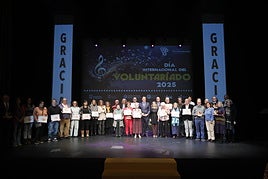 Los voluntarios reconocidos por su labor se hacen la tradicional foto de familia con el alcalde de la ciudad, Carlos García Carbayo.