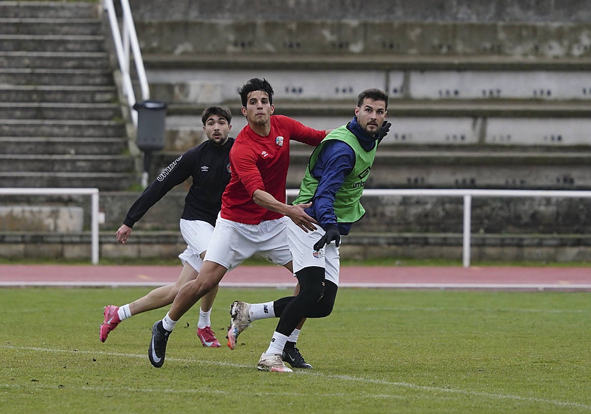 El delantero del Salamanca UDS Javi Delgado busca el remate mientras es agarrado por Rivas en un entrenamiento de la presente semana.
