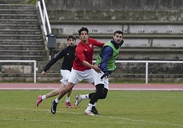 El delantero del Salamanca UDS Javi Delgado busca el remate mientras es agarrado por Rivas en un entrenamiento de la presente semana.