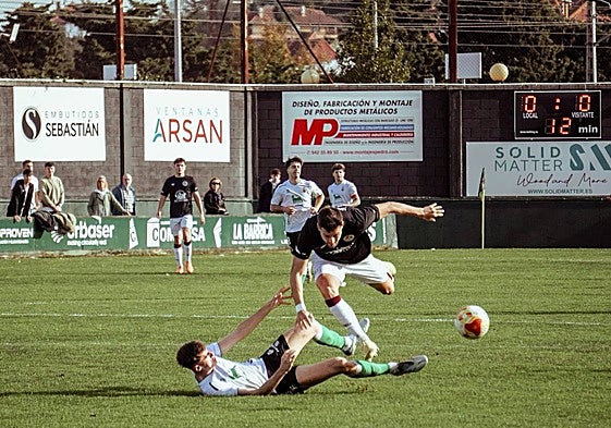 Javi Delgado cae al suelo después de ser agarrado por un zaguero local cuando ya encaraba la portería del Rayo Cantabria.