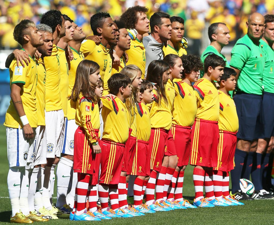 Los futbolistas de Brasil cantan el himno.