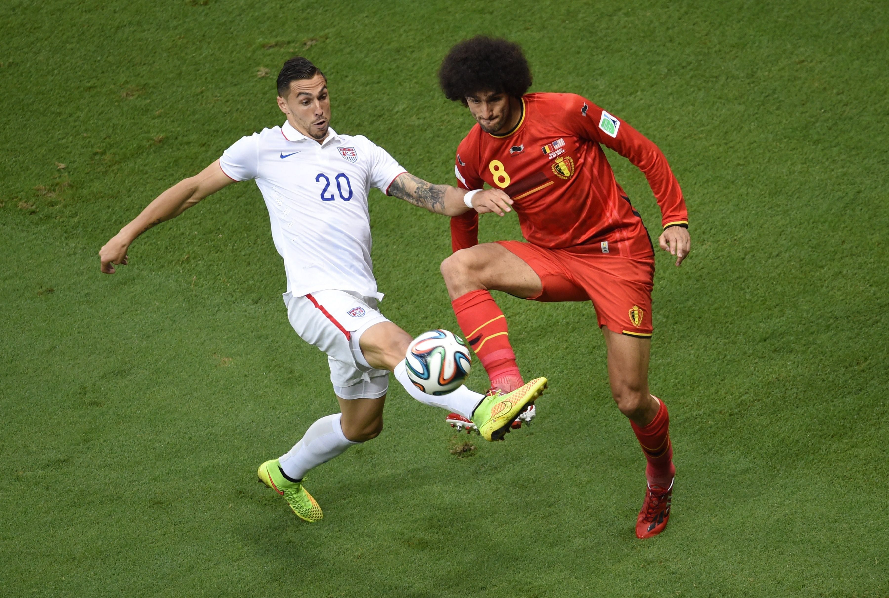 Marouane Fellaini (d) y el estadounidense Geoff Cameron pelean un balón.