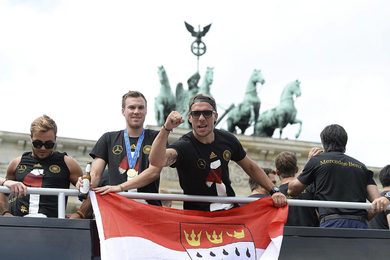 LA SELECCIÓN ALEMANA CELEBRA LA COPA DEL MUNDO CON MILES DE AFICIONADOS. Mario Goetze (i-d) Kevin Grosskreutz y Lukas Podolski celebran la Copa del Mundo con los cientos de miles de aficionados que recibieron al combinado alemán en la Puerta de Brandeburgo en Berlín.