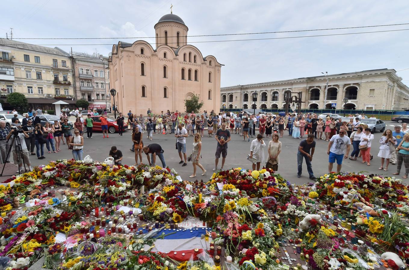 Gente depositando flores y velas frente a la embajada de Holanda en Kiev.