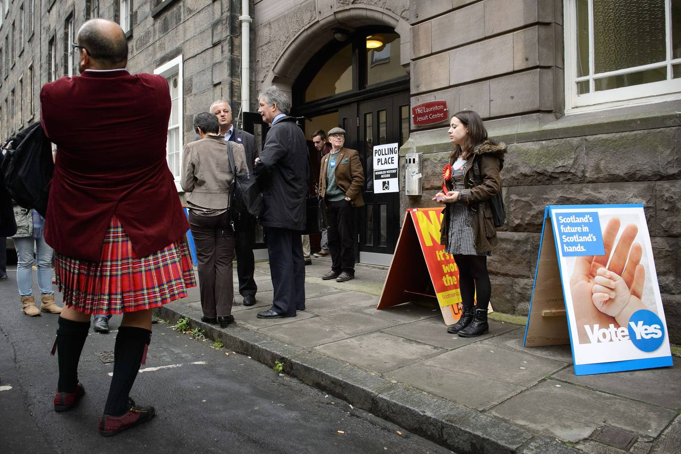 Escocia ya decide su futuro. Algunos escoceses salen y entran de un colegio electoral de Edimburgo.