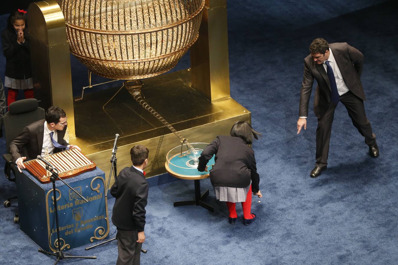 Los niños de San Idelfonso recogen la bola premiada con mil euros que se había caido al suelo, durante el sorteo.