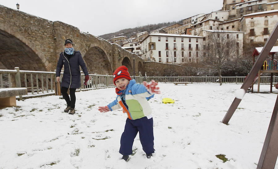 Un niño y su madre juegan con la nieve en Villoslada de Cameros.