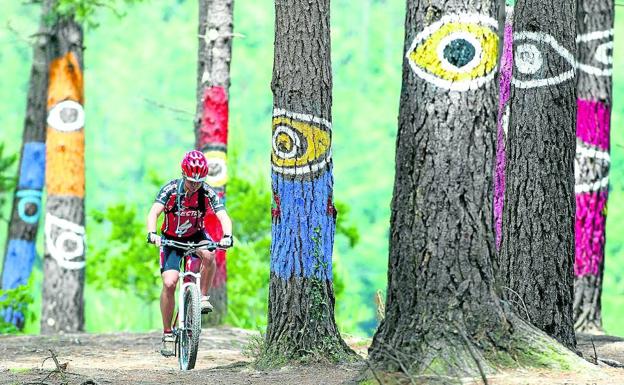 Los ojos de Ibarrola observan el paso de un ciclista por el bosque de Oma.