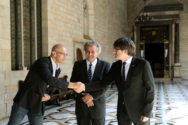 Raül Romeva y Carles Puigdemont se saludan en presencia del Premio Nobel de la Paz 2015, el tunecino Ahmed Galai. :: t. albir / efe