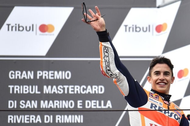 Marc Márquez celebra la victoria en el podio de Misano. :: Marco BERTORELLO / afp