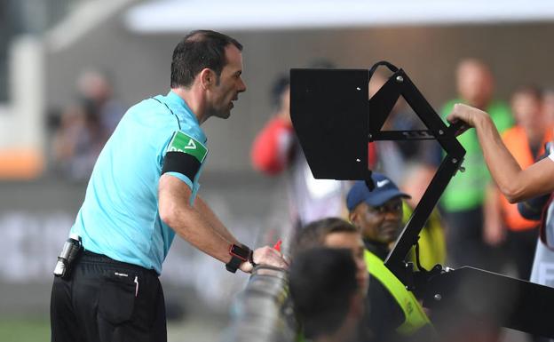 El árbitro Marco Fritz usando el VAR en un partido de la liga alemana.