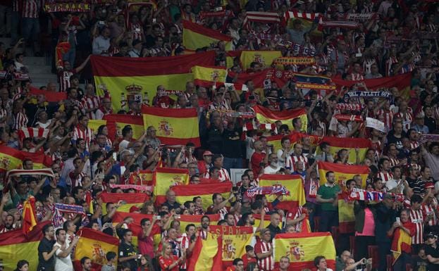 Aficionados del Atlético portando banderas de España. 