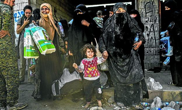 Mujeres y niños se reúnen en el frente oeste después de abandonar el centro de Raqqa. :: BULENT KILIC / afp