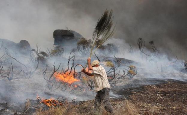 Un hombre trata de sofocar las llamas del incendio desatado en la población de Almeidinha, cerca de la frontera con la provincia española de Salamanca. 