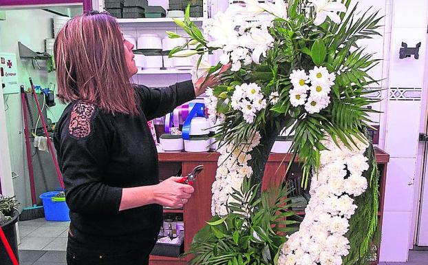 En la floristería Trébol, Eva Mª López prepara una corona . 