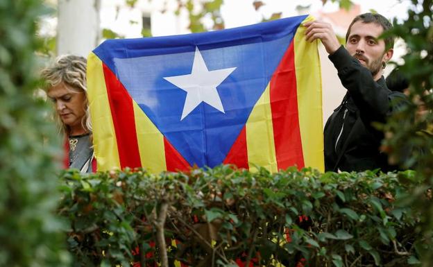 Varias personas sostienen una estelada a las puertas de la Audiencia Nacional. 