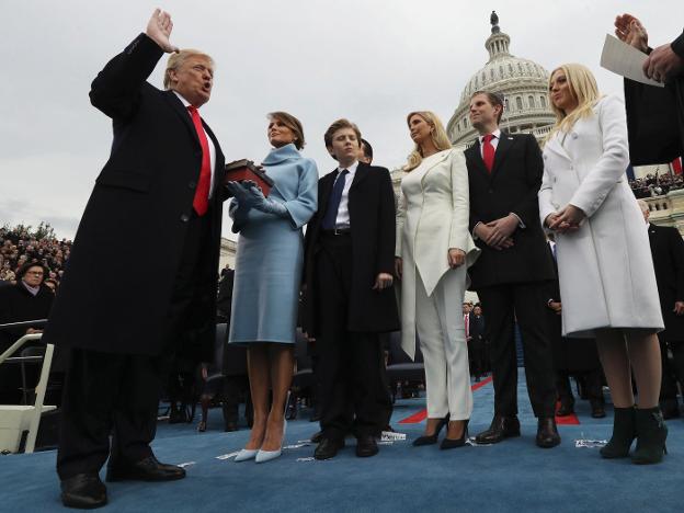 Donald Trump jura el cargo de presidente, mientras su esposa Melania sostiene la Biblia, en presencia del resto de la familia. :: JIM BOURG / afp