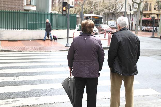 Una pareja de jubilados espera a cruzar una calle en Madrid. :: r. c.