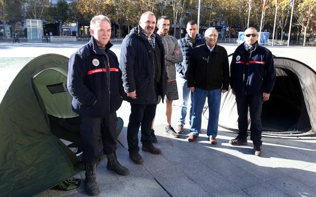 Varios compañeros del parque de bomberos de Logroño comparten charla con los bomberos acampados. 