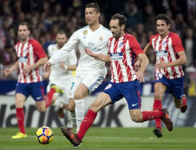 Cristiano Ronaldo y Juanfran, en la disputa de un balón durante el partido disputado ayer en el Metropolitano. :: EDUARDO DIEGUEZ / AFP