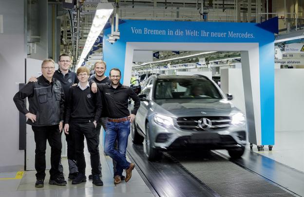 Uno trabajadores de la planta de Bremen, con el vehículo 8 millones de Mercedes. :: L.R.m.