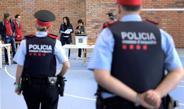 Un agente de los Mossos contempla la votación. :: cesar manso/AFP