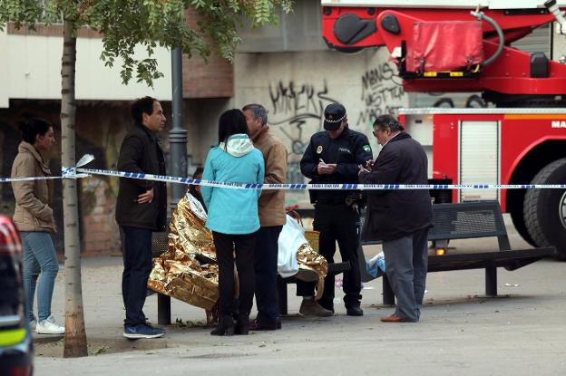 Varios vecinos conversan al pie del edificio en el que se produjo el incendio. :: P. Torres / efe