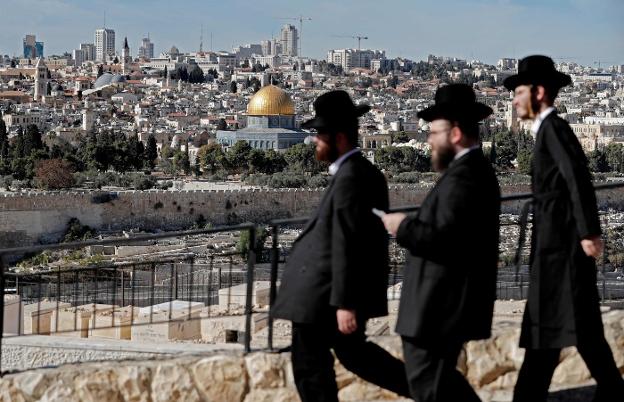 Judíos ultraortodoxos pasean por el Monte de los Olivos, con una panorámica de Jerusalén al fondo. :: THOMAS COEX / afp