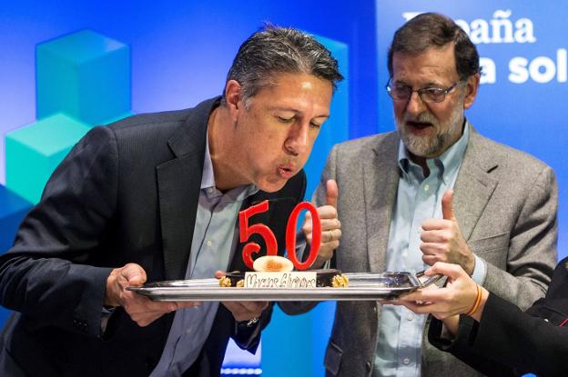 Albiol sopla las velas de su tarta de cumpleaños ayer junto a Rajoy en Lleida. :: Quique García / efe