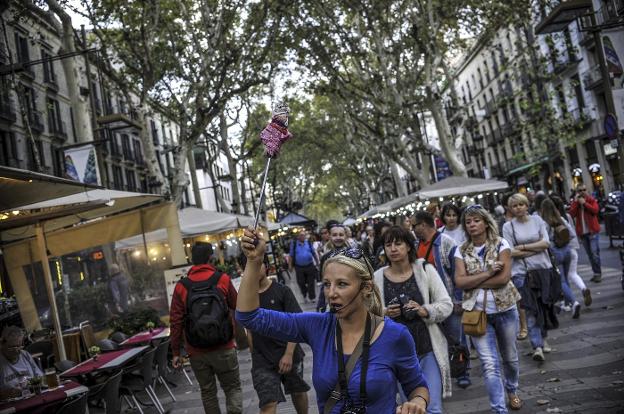 Una guía señala el camino a un grupo de turistas en la siempre masificada Rambla de Barcelona. :: ignacio pérez

