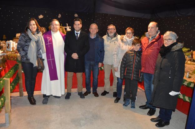 Foto de familia de los representantes de Amigos de Arnedo, el sacerdote y el alcalde en el belén. 