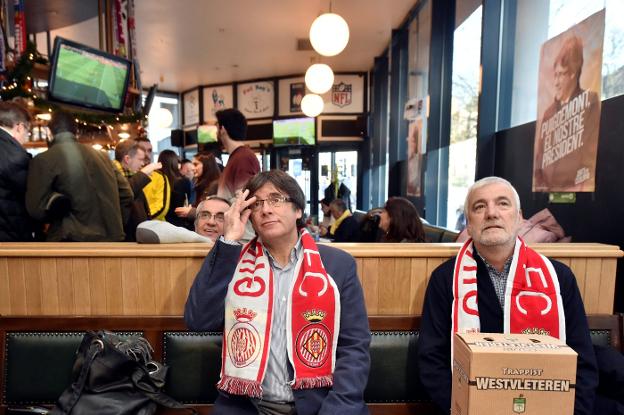 Puigdemont, con la bufanda del Girona, sigue el partido en una cafetería de Bruselas. :: Eric Vidal / reuters