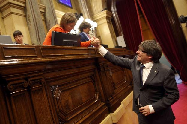 Puigdemont saluda a la presidenta del Parlament, Carme Forcadell, tras uno de los tormentosos plenos de septiembre pasado. :: toni albir / efe